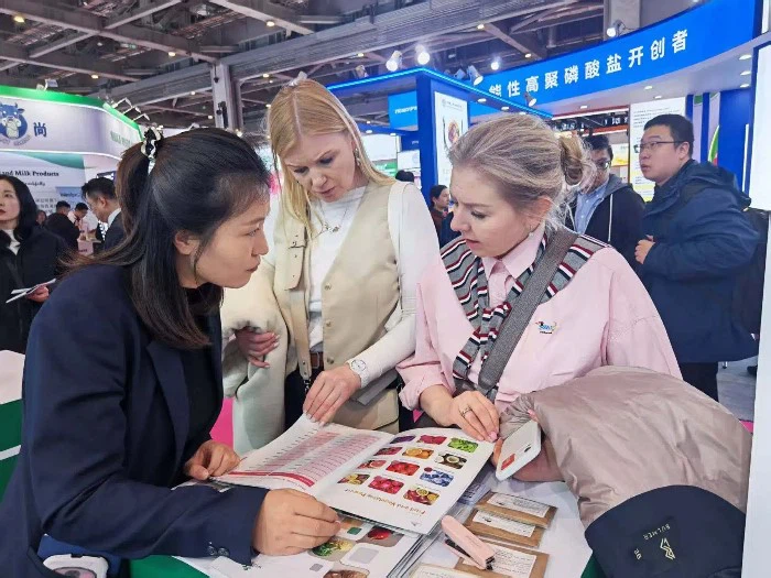 A group of attendees gathers around the display to learn about sustainable sourcing. A group of attendees gathers around the display to learn about sustainable sourcing.